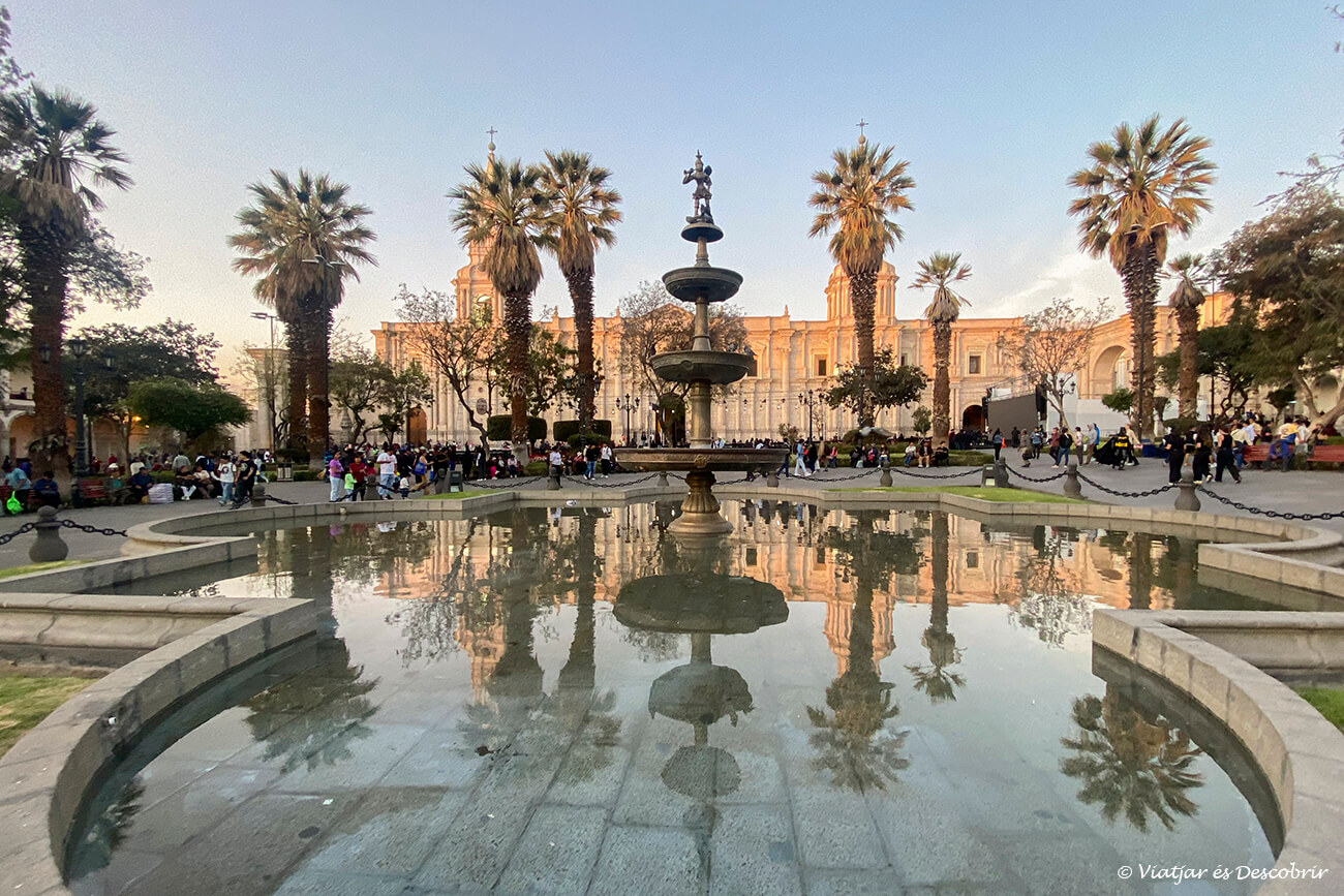 vista de la font de la Plaza de Armas d'Arequipa amb els edificis reflectits durant la posta de sol