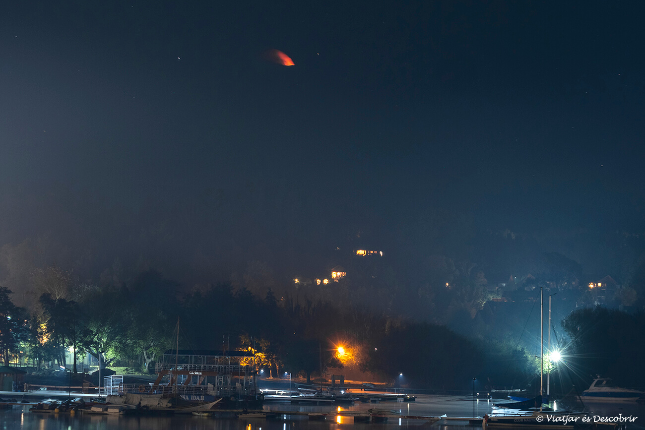 Pucón a la nit sota una fina boira i el volcà Villarrica al fons